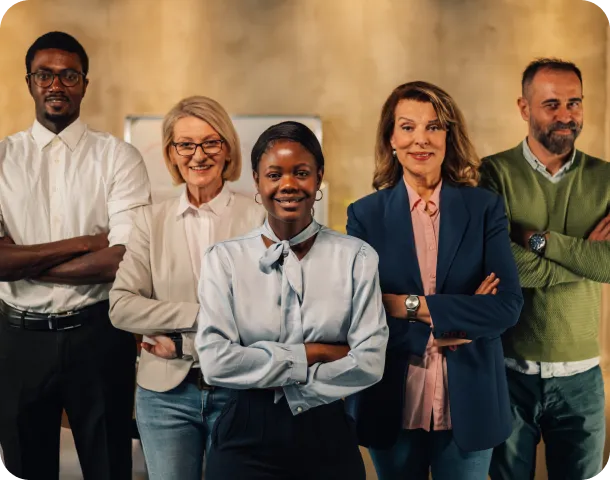 interracial staff with arms crossed at modern offi